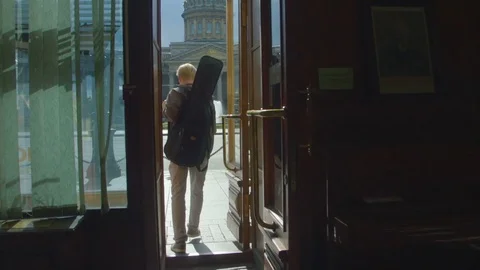 The musician walks out of the store Stock Footage 80249257