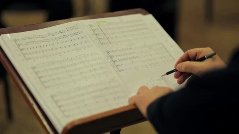 Musician writes on a sheet of notes. Video stock 72649018