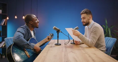 Musicians collaborating on a live podcast broadcast, guest plays guitar Stock Footage 328973295