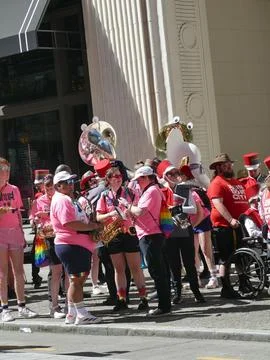 Musicians playing wind instruments during a pride event, showing rainbow fl.. Stock Photos