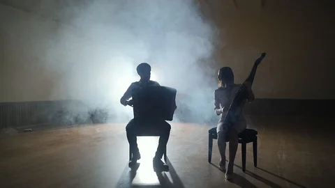 Musicians silhouettes playing and falling sheets, smoke on background in slowmo Stock Footage 106701667
