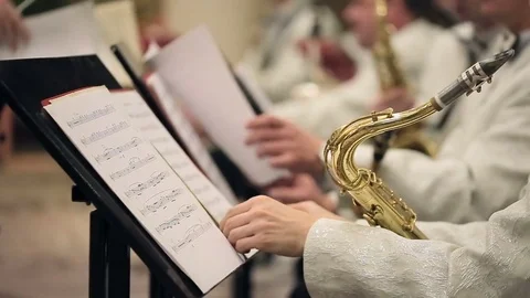 Musicians working with notes and playing on saxophone in concert. Stockbeeldmateriaal 74673731