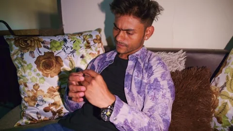 Musing man sitting on the sofa displaying unease Stock-Footage 302634094