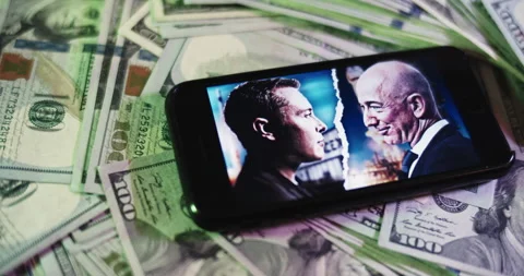 Musk Vs Bezos Image on iphone surrounded by $100 Bills. Stock Footage 169006819