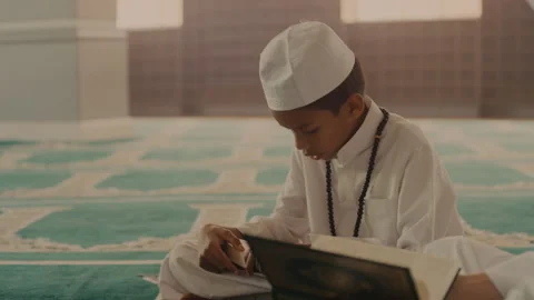 Muslim boy reading something from a holy book Stock Footage 279708741