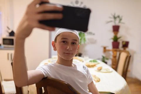 A Muslim boy taking a selfie while having an iftar during Ramadan Stock Photos