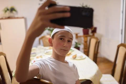 A Muslim boy taking a selfie while having an iftar during Ramadan Stock Photos
