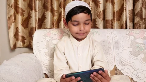 Muslim boy thinking and Typing on phone During E-Learning Stock Footage 126605767