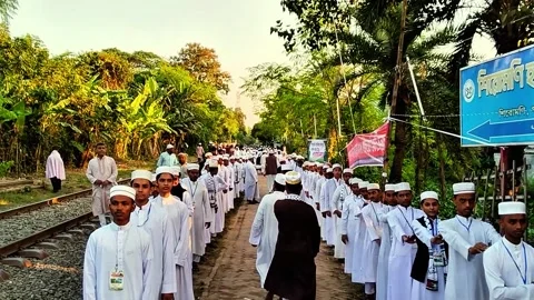 Muslim congregation walking in procession amidst lush greenery and tropical 스톡 동영상 318131476