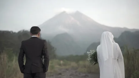 A Muslim couple standing facing Mount Merapi in Yogyakarta, Indonesia. Stock Footage 248941382