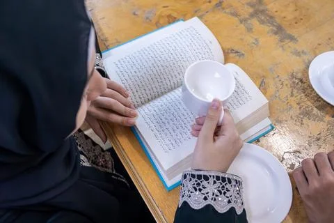 Muslim couples reading book while drinking coffee Stock Photos