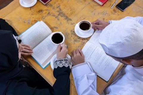 Muslim couples reading book while drinking coffee Stock Photos