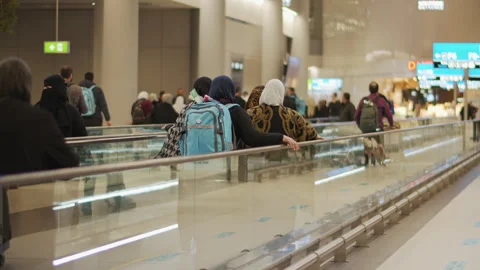 Muslim crowd walking on an escalator walkway at the airport terminal. Stock Footage 130320835