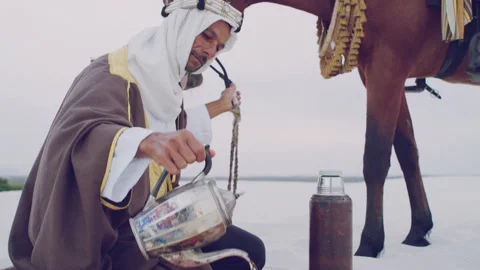 Muslim doing a prayer next to his horse during the day Stock Footage 279717608