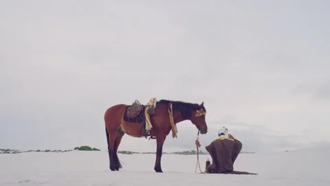 Muslim doing a prayer next to his horse Stock Footage 279720211