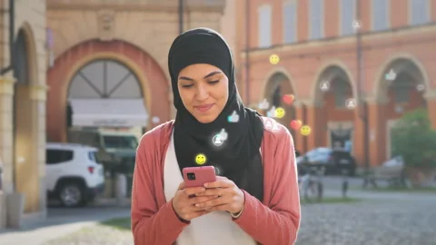 Muslim female walking using smart phone social media network icon visualization Video stock 252814707