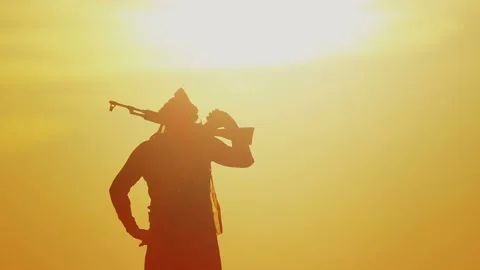 Muslim fighter is training with a machine gun at sunset. Vidéo 118514975