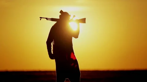 Muslim fighter is training with a machine gun at sunset. Vidéo 118520669