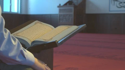 Muslim guy scrolling through Quran in empty mosque Stock Footage 88033164