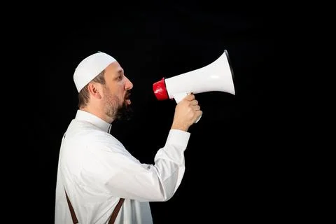 Muslim man with beard shouting through megaphone calling for Hajj Stock Photos