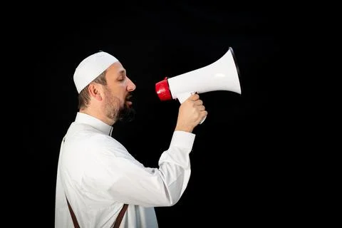 Muslim man with beard shouting through megaphone calling for Hajj Stock Photos