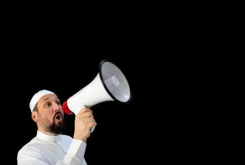 Muslim man with beard shouting through megaphone calling for Hajj Stock Photos