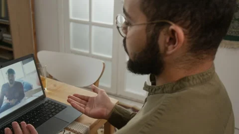 Muslim Man Discussing Work Projects via Video Chat at Home Stock Footage 331828932