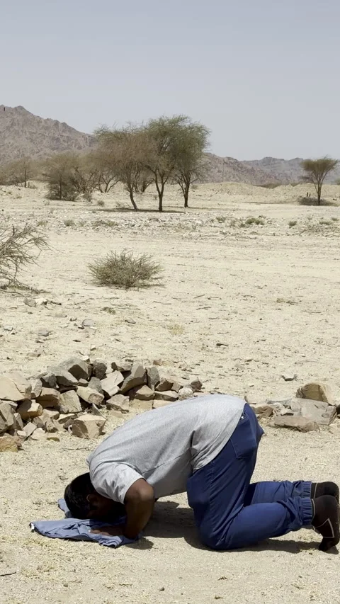 Muslim Man Praying in Remote Arid Desert Landscape Stock Footage 332031689