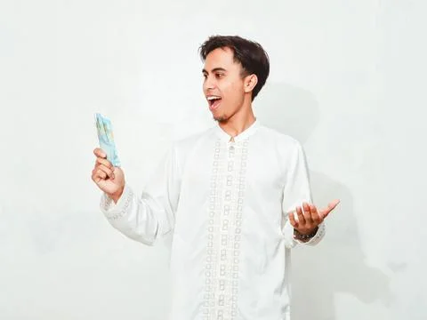 Muslim man showing surprised expression while holding money,on isolated whi.. Stock Photos