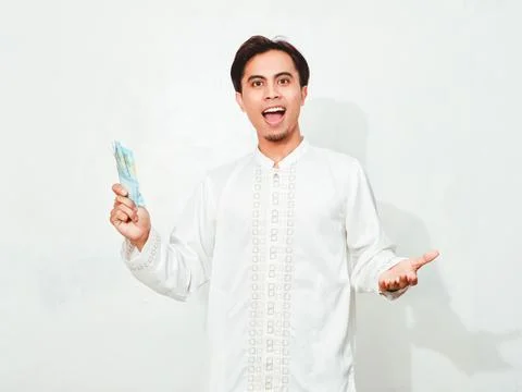 Muslim man showing surprised expression while holding money,on isolated whi.. Stock Photos