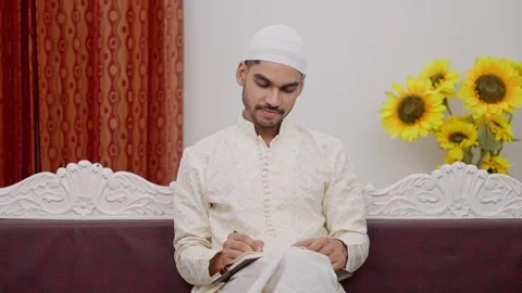 Muslim Man Sitting on Sofa Writing in Notebook and Smiling Stock Footage 296985332