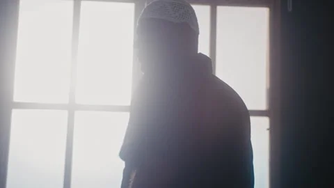 Muslim man standing in front of a window Stock Footage 275311884