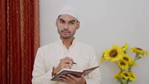 Muslim Man Thinking and Writing in Notebook Stock Footage 296983959