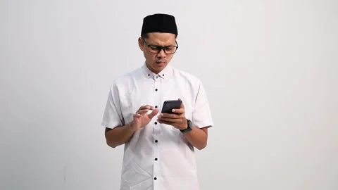 Muslim man using cellphone with disappointed and angry expression, in problem Stock Footage 327695417