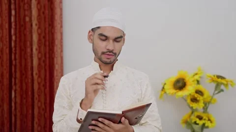 Muslim Man Writing in Notebook while Thinking Stock Footage 296984000