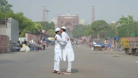 Muslim men celebrating Eid and exchanging gifts in front of mosque Stock Footage 235275657