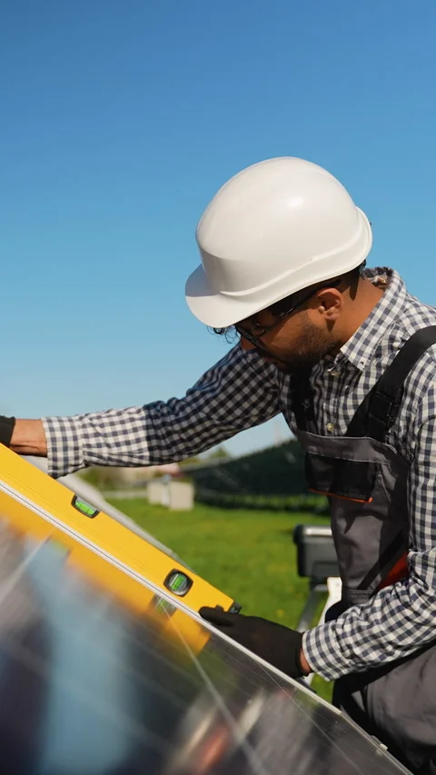 Muslim technician installing solar panel with spirit level Stock Footage 314410466