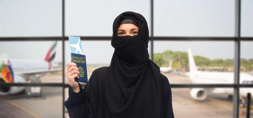 Muslim woman with air ticket and immunity passport Stock Photos