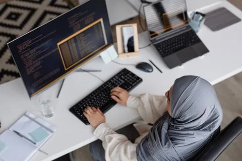 Muslim Woman Coding with Multiple Computer Devices Foto stock