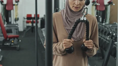 Muslim Woman Doing Standing Pulldowns with Cable Machine Stock Footage 167014963