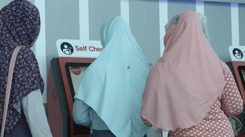 Muslim Women Using Self-Service Check-In Kiosk Video stock 65728811