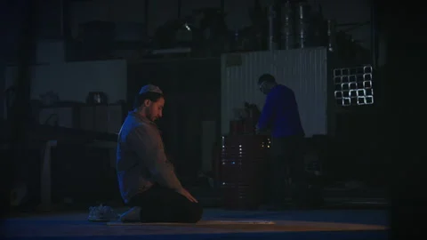 Muslim worker sitting in prayer position at workplace Stock Footage 317582501