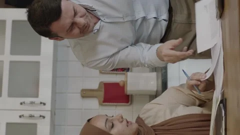 Muslim young couple checking payment bills in kitchen at home. Stock Footage 204713786