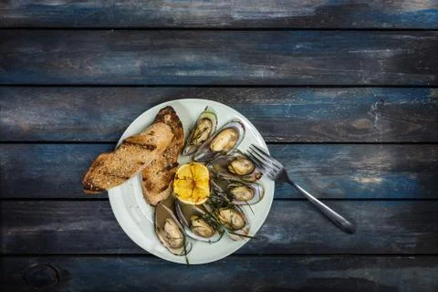 Mussels and bread toasts on on a white plate. Top view Stock Photos