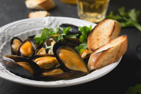 Mussels with parsley and crispy baguette Stock Photos