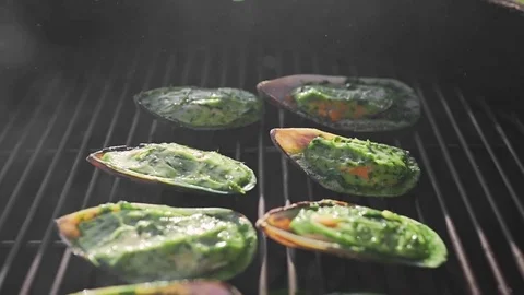 Mussels is roasted in the sauce on the open fire of grill, cooking outdoors Stock Footage 77548583