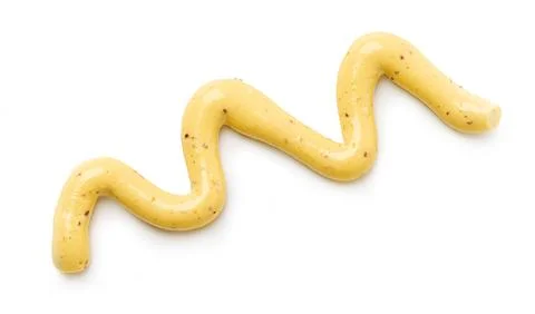 Mustard sauce zigzag pattern drizzle on white background Stockfoto's