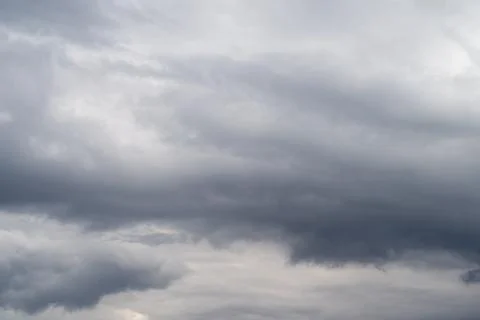 Muted dramatic clouds in calm before storm, wide horizontal layers and gentle Stock Photos