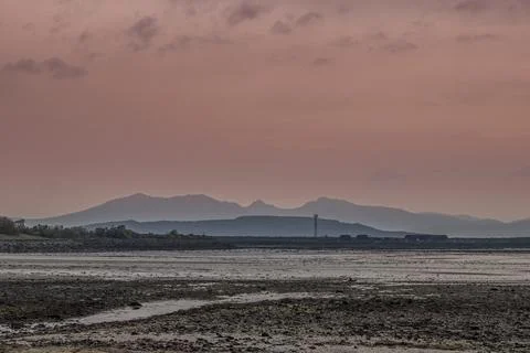 Muted pink sky meets distant hazy Arran mountains Stock-Fotos
