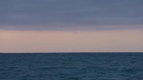 Muted setting sun over choppy seas Stock Footage 305957350